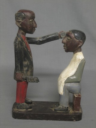A wooden figure in the form of a Native barber 12"