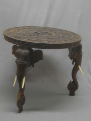 A circular Eastern carved hardwood occasional table, raised on elephant supports 27"