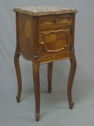 A 19th Century French carved walnut bedside cabinet of serpentine outline with pink veined marble top, fitted a drawer above a cupboard, raised on cabriole supports 15"