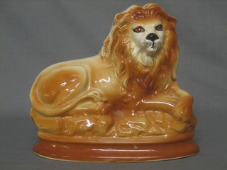 A 19th Century Staffordshire figure of a seated lion, the eyes set hardstones 9"