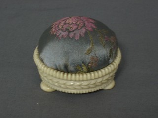 A Regency circular carved ivory pin cushion in the form of a basket raised on bun feet 3"
