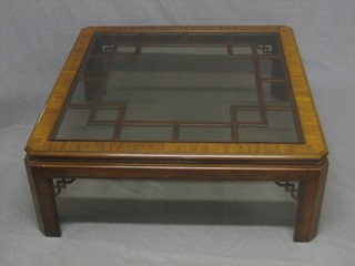 A square Chippendale style mahogany coffee table with lattice work decoration and plate glass top, raised on square supports 42"