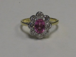 An 18ct white gold dress ring set an oval cut pink sapphire supported by diamonds, approx 0.75ct 