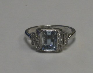 An 18ct white gold dress ring set a square cut aquamarine supported by 2 rows of diamonds