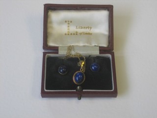 A gilt metal chain hung a cabouchon cut lapis lazuli pendant and matching ear studs, contained in a Liberties box