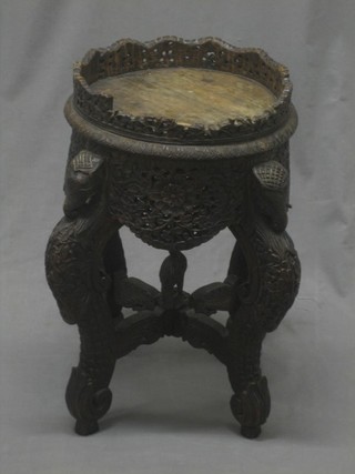 A circular Eastern carved jardiniere stand raised on cabriole supports decorated elephants 11"