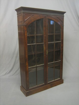 A 19th Century mahogany bookcase with moulded cornice, the interior fitted adjustable shelves enclosed by astragal glazed panelled doors and raised on a platform base 35" 