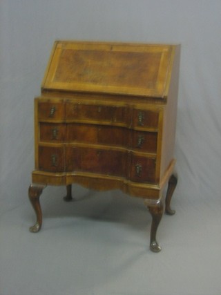 A Queen Anne style walnut bureau with crossbanded top, the fall front revealing a well fitted interior, the base of serpentine outline with 3 long drawers raised on cabriole supports 24"