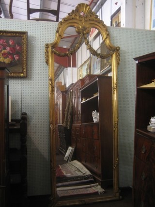 A rectangular shaped plate mirror contained in a decorative gilt frame with swag decoration 93"