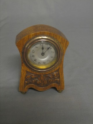 A mantel clock with silvered dial and Arabic numerals contained in a carved oak case 3" 