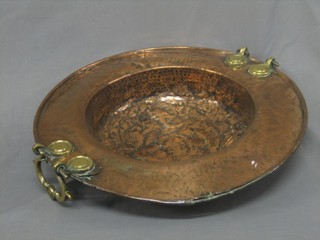 A circular Eastern embossed copper bowl with brass handles 22"