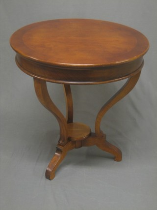A circular Continental mahogany centre table, raised on scroll supports 25"