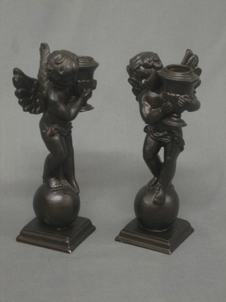 A pair of resin candlesticks in the form of standing cherubs 8"