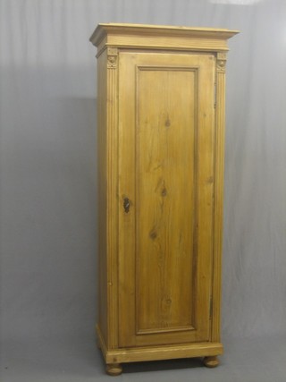 A pine Sentry box style cupboard fitted shelves and enclosed by a panelled door, raised on bun feet 28"