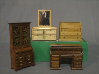 A collection of dolls house furniture including a mahogany bureau bookcase, roll top desk, bureau and dressing chest