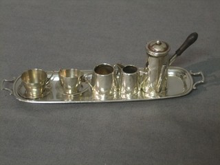 A dolls house silver coffee service comprising rectangular twin handled tea tray, 2 cups and 2 saucers, side handled coffee pot, twin handled sugar bowl and cream jug