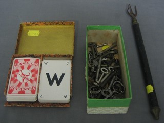 A toasting fork, a  small collection of keys and set of Kanugo playing cards