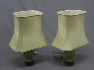 A pair of Celadon green pottery table lamps in the form of urns together with green shades