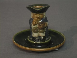 A Doulton Lambeth candle stick in the form of a seated Toby Philpot, base impressed 8585 4" (base f and r) 