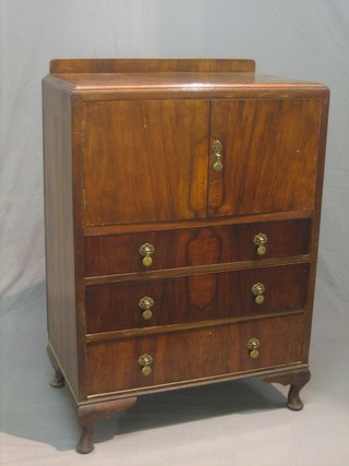 An Art Deco walnut tallboy fitted a double cupboard above 3 long drawers, raised on cabriole supports 30"