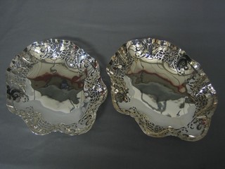 A pair of pierced oval silver plated dishes raised on bun feet 11"