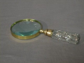 A circular magnifying glass with faceted glass handle