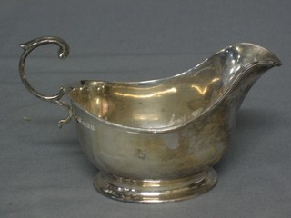 A silver sauce boat with C scroll handle, raised on an oval spreading foot Birmingham 1928, 4 ozs 