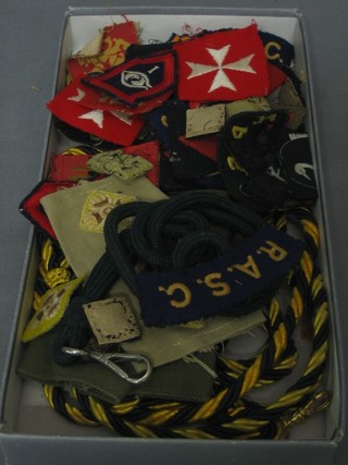 A collection of military cloth insignia including Divisional badges, shoulder titles etc
