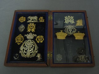 A shallow box containing various 19th Century pierced metal armorial book embellishments