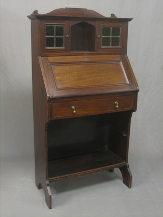 An Edwardian Art Nouveau mahogany student's bureau, the upper section fitted a recess flanked by a pair of cupboards enclosed by lead glazed panelled doors, the base fitted a fall front revealing a well fitted interior above 1 long drawer, 28"
