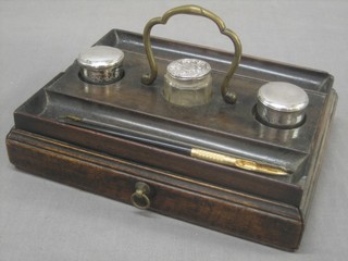 A 19th Century ink stand fitted a drawer with 3 wells to the centre containing 2 silver plates jars with armorial decoration and a glass jar with silver lid
