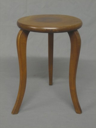 A circular walnut stool raised on cabriole supports 9"