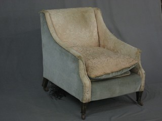 A mahogany framed armchair upholstered in cream coloured material raised on square tapering supports in castors