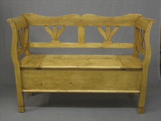 A Continental stripped and polished pine settle, the seat with hinged lid 50"
