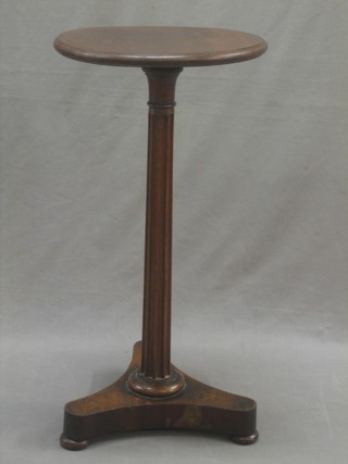 A William IV circular mahogany wine table raised on a fluted turned column with triform base 15"