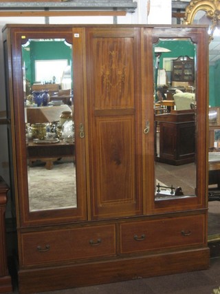 An Edwardian inlaid mahogany double wardrobe, the interior fitted a hanging space enclosed by a pair of bevelled plate mirrored doors, the base fitted 2 long drawers raised on a platform base 59" (missing cornice)