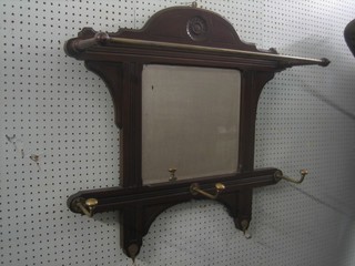 An Edwardian mahogany hanging coat rack incorporating a bevelled plate mirror 31"