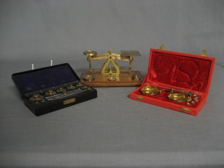 A brass letter scale, a gold balance and a set of weights