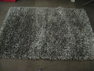 A contemporary grey ground shag pile carpet 72" x 50"