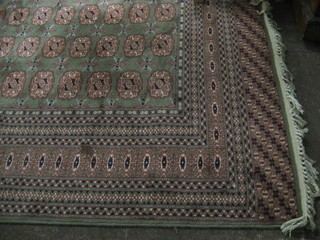 A machine made green ground Bokhara style carpet with numerous octagons to the centre 130" x 99"