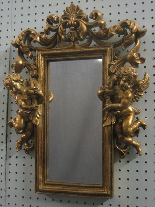 A rectangular plate mirror contained in a decorative gilt frame decorated cherubs 17" 