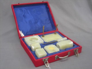 A presentation onyx 7 piece desk set comprising pen holder, ashtray, pin tray, paperweight, stamp moistener, vase and paper knife, all contained in a plush case