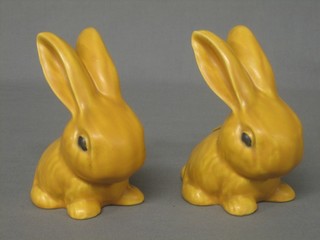A pair of orange glazed Sylvac style figures of seated rabbits 6"