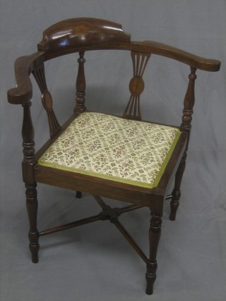 An Edwardian inlaid mahogany corner chair with upholstered seat raised on turned supports