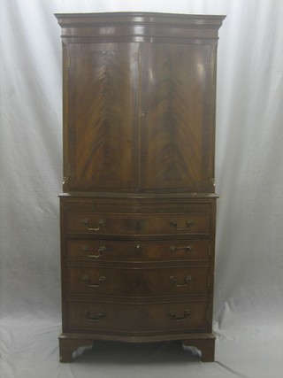 A Georgian style mahogany cocktail cabinet on chest of serpentine outline, the upper section with moulded cornice fitted a cabinet enclosed by panelled doors, the base fitted a brushing slide above 1 long drawer with cupboard beneath, raised on bracket feet 28" 