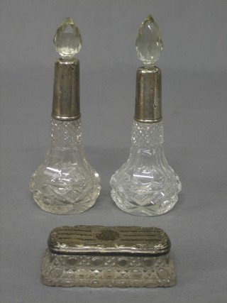A pair of cut glass dressing table bottles with silver collars together with a rectangular cut glass pin jar with silver lid