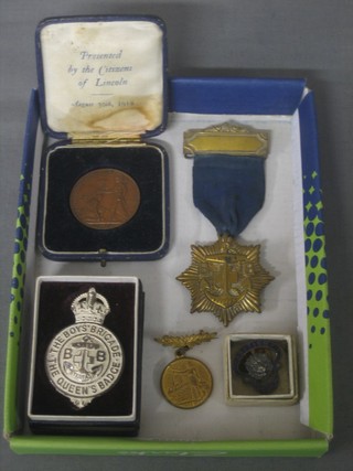A bronze medallion for Services in The Great War presented by the People of Lincoln cased, a bronze 1919 Peace Medal, a Boys Brigade cap badge The Queens Badge and a Royal British Legion badge