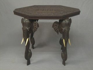 An Eastern carved hardwood lozenge shaped occasional table, raised on elephant head supports 30"