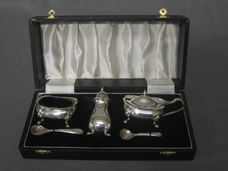 A silver plated 3 piece condiment set comprising mustard, salt and pepper together with a spare blue glass liner