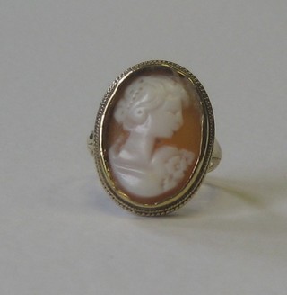 A gold dress ring set an oval shell carved cameo portrait of a lady